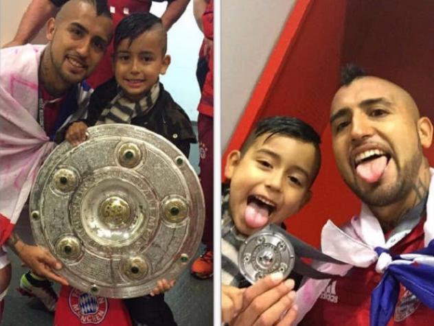 Arturo Vidal festeja levantando el trofeo de campeón junto a su hijo en Alemania